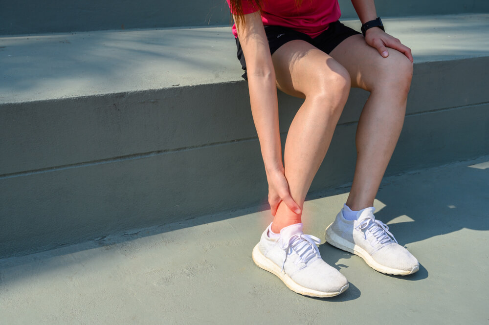 What commonly causes pain in the side of the ankle?