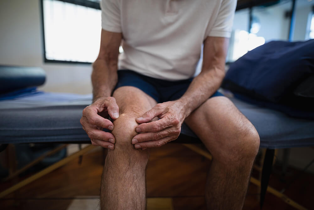 Knee popping after ACL surgery? Learn why & what to do about it midsection of senior male patient holding knee in 2021 08 28 16 46 28 utc Knee popping after ACL surgery? Learn why & what to do about it
