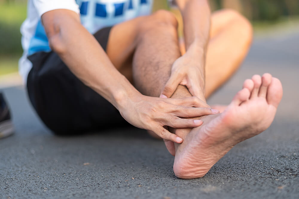 10 causes of pain on top of the foot near the ankle young fitness man holding his sports leg injury 2023 11 27 05 11 29 utc 1 10 causes of pain on top of the foot near the ankle